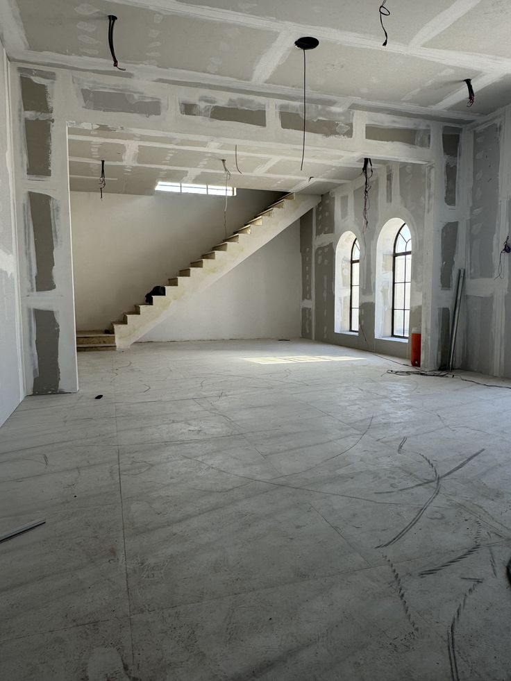 Before — the shell of the villa living room, bare drywall and concrete floor